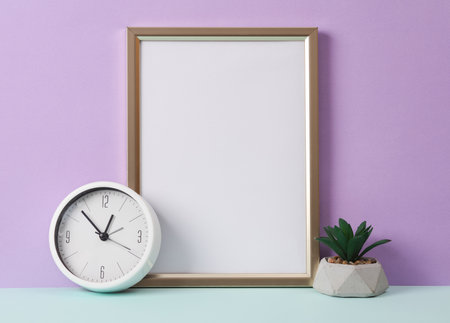 Photo frame with a white sheet of paper (mockup) and decor on a pastel background. Minimal still lifeの写真素材