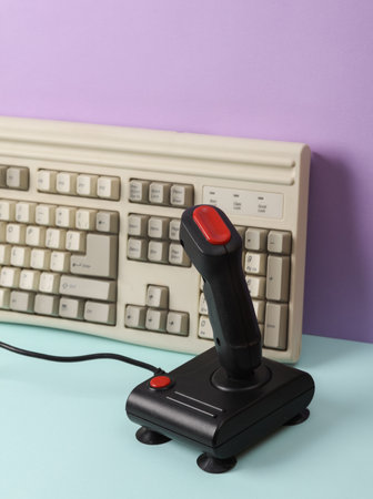 Creative retro 80s layout with old keyboard and joystick on pastel background. concept pop. Minimal...