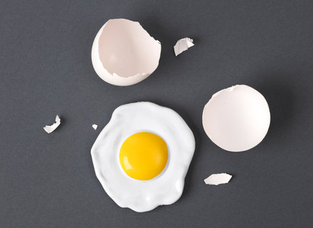creative layout. Scrambled eggs with eggshell on gray background. concept pop. Minimal food still life.の写真素材
