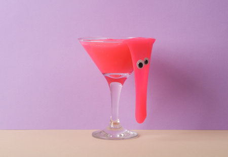 Creative layout, cocktail glass with neon slime and eyes on two tone pastel background. visual trend. Minimalistic aesthetic still life. Party halloween concept. fresh ideasの写真素材