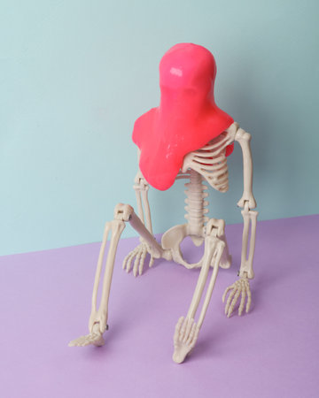 Minimalism halloween still life. Skeleton with slime on two tone pastel background. fresh ideas....