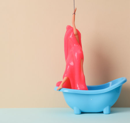Creative layout, doll with slime in the bath on two tone pastel background. visual trend