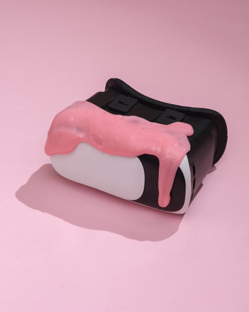 Creative layout, VR glasses with slime on pink background with shadow. visual trend. fresh ideas....