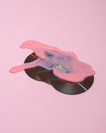 Creative layout, cd discs with slime on pink background with shadow. visual trend. fresh ideas....