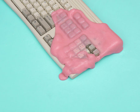 Creative retro layout, Old keyboard with slime on blue pastel background. visual trend. fresh ideas