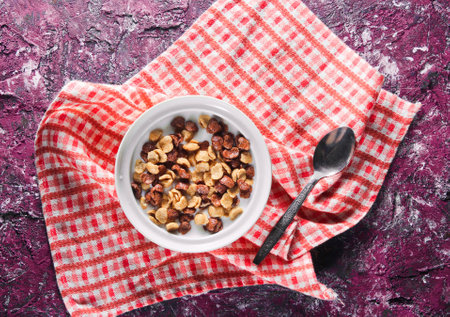 Quick breakfast cornflakes in milk on the tablecloth. rustic style on violet concrete table. top...