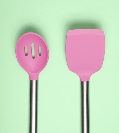 Set of tools for cooking on green background. Silicone paddles with metal handles. top view. copyspace.の写真素材