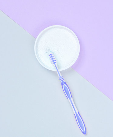 Toothbrush and tooth powder on a gray-purple paper background. top viewの写真素材