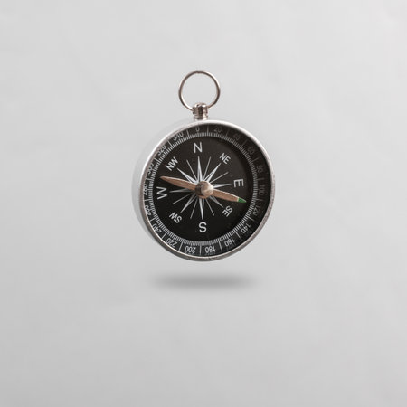 Compass levitating on gray background with shadowの写真素材