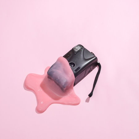 creative minimalist layout. Camera with slime on a pink background. Surreal summer ideas. Conceptual popの写真素材