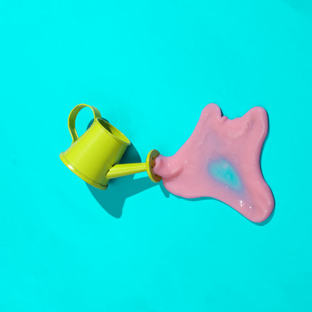creative minimalist layout. Watering can with slime on a blue background. Surreal summer ideas. Conceptual popの写真素材