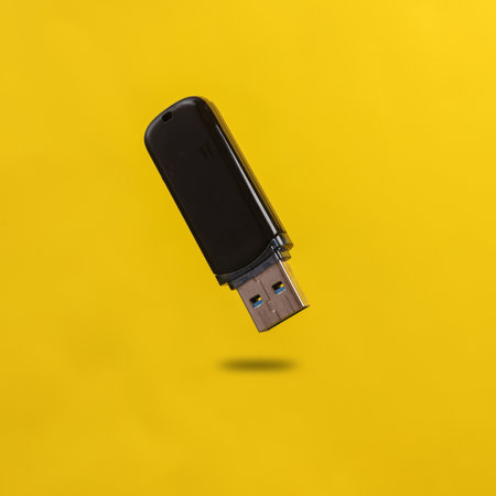 Usb flash drive levitating on yellow background with shadow
