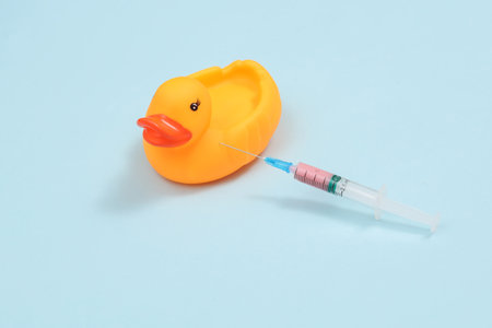 vaccination. Rubber duck with a syringe on a blue backgroundの写真素材