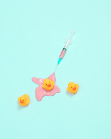 creative minimalist layout. syringe with ducks on pink background. Surreal medicine idea. Conceptual popの写真素材