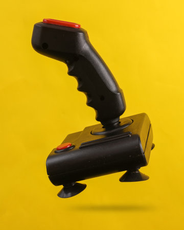 Retro joystick levitating on a yellow background with a shadowの写真素材