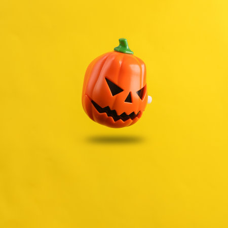 Halloween pumpkin jack levitating on yellow background with shadowの写真素材