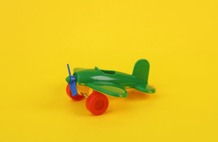 Toy airplane with propeller on yellow backgroundの写真素材