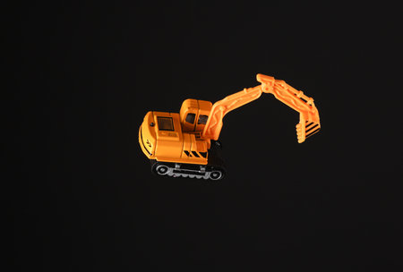 Toy excavator isolated on black backgroundの写真素材
