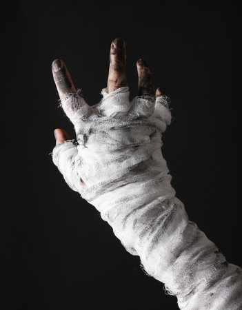 Mummy's hand wrapped in a bandage isolated on a black background. halloween concept