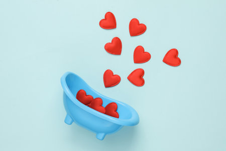 Miniature bathroom sink with hearts on a blue background. Romantic, love, valentine's day concept