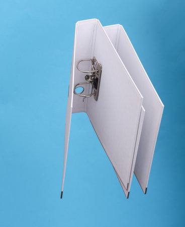 Empty White binder with rings levitating on blue background