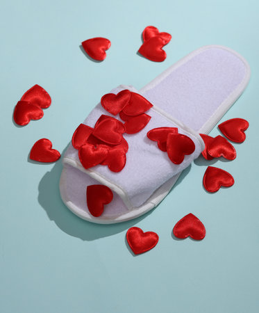 White slippers with hearts on blue background. Love concept, valentine's day, february 14th...
