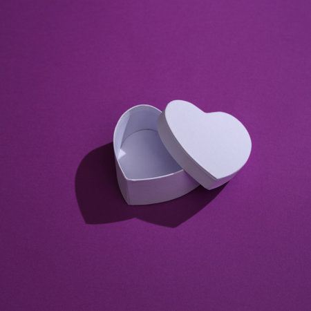 Empty white box in shape of heart on a purple backgroundの写真素材
