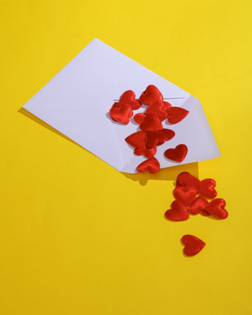 White envelope with hearts on a yellow background. Valentine's day, love conceptの写真素材