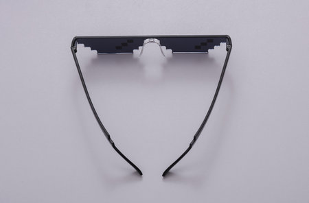 Pixelated 8 bit sunglasses on a gray backgroundの写真素材