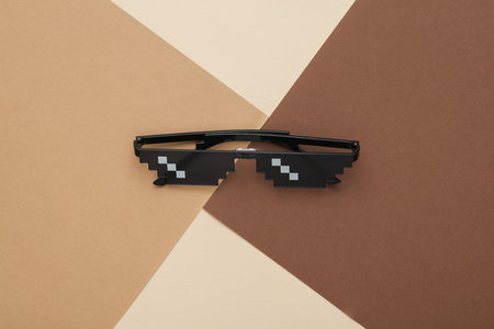 8 bit pixelated sunglasses on a brownish beige backgroundの写真素材