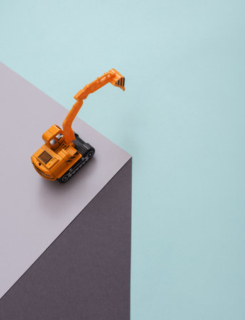 Toy excavator on paper cube. optical illusion. geometric composition. minimalist creative layoutの写真素材