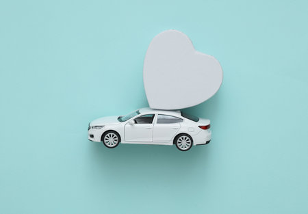 Valentine's Day. gift delivery. Toy car with a heart box on blue backgroundの写真素材