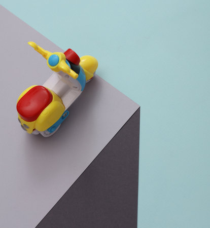 Toy moped on a paper cube. optical illusion. geometric composition. minimalist creative layoutの写真素材