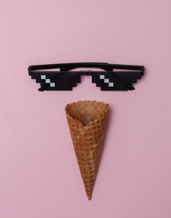Waffle cone with Pixelated 8 bit sunglasses on pink backgroundの写真素材