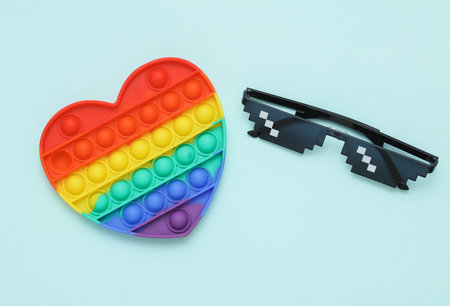 Pixelated 8 bit sunglasses with pop it antistress toy on pastel backgroundの写真素材