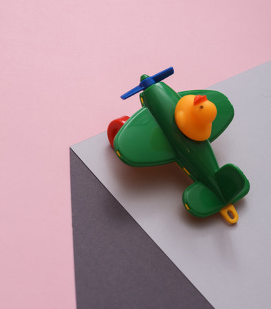 Toy air plane with rubber duck on a paper cube. optical illusion. geometric composition. Minimalist creative layout. travel conceptの写真素材