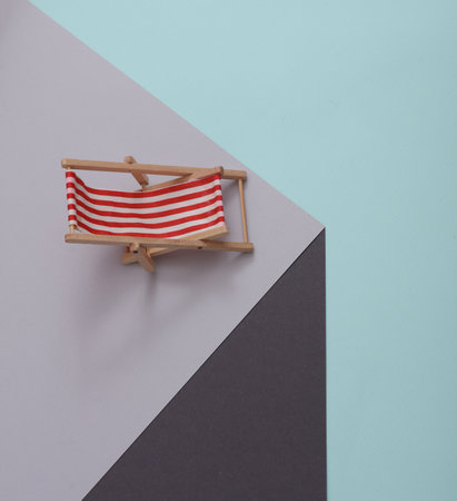 Deck chair on a paper cube. optical illusion. geometric composition. minimalist creative layoutの写真素材