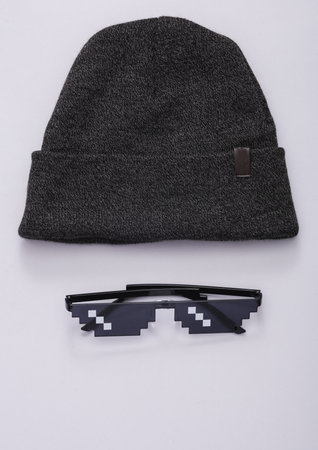 Pixelated 8 bit sunglasses with hat on a gray backgroundの写真素材