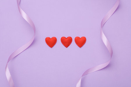 Blank holiday background with hearts and satin lavender ribbonの写真素材