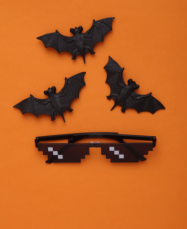 Bats with pixel sunglasses on an orange background. halloween conceptの写真素材
