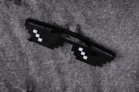8 bit pixel sunglasses on denim background