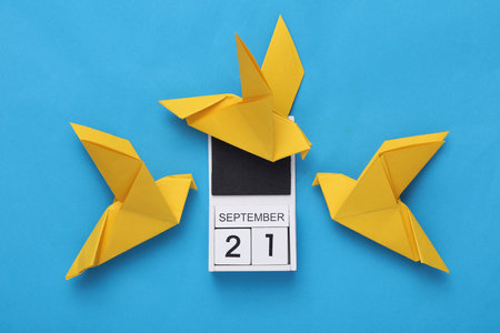 world peace day. Origami Dove and calendar with date september 21, blue backgroundの写真素材