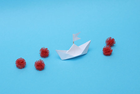 White paper boat with virus molecules on a blue backgroundの写真素材