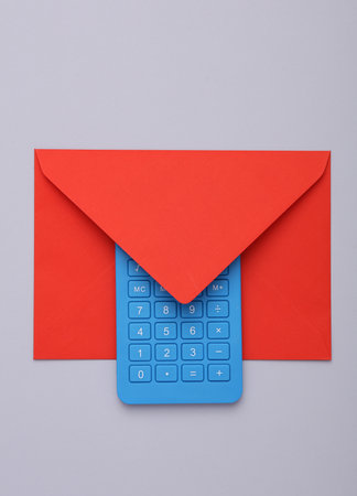 Envelope with a calculator on gray background. business conceptの写真素材