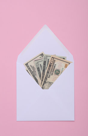 White envelope with dollars on a pink backgroundの写真素材