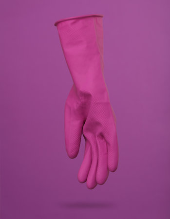 Purple cleaning rubber glove levitating on purple background with a shadow. cleaning conceptの写真素材