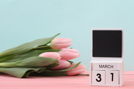 Block wooden calendar with the date March 31 and tulips on a pastel background. spring compositionの写真素材