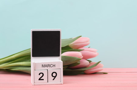 Block wooden calendar with the date March 29 and tulips on a pastel background. spring compositionの写真素材