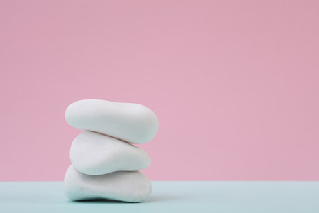Stack of white pebbles on a pastel backgroundの写真素材