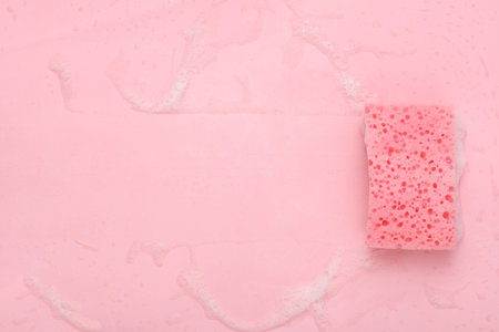 Sponge with foam on a pink background. cleaning concept. copy spaceの写真素材